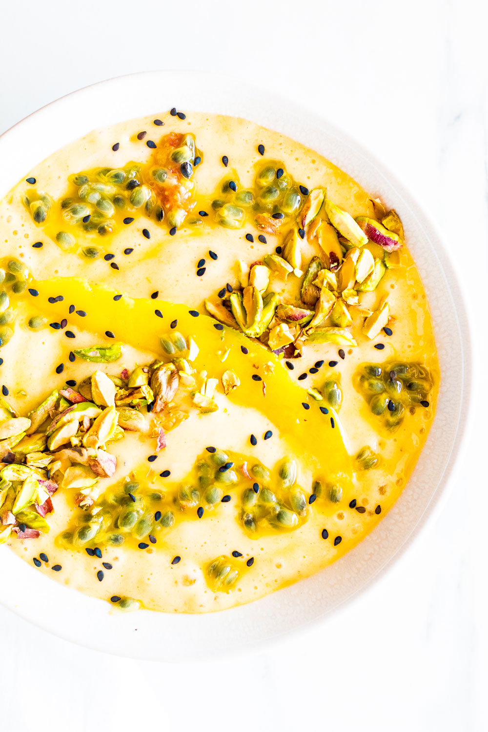 This Mango, Banana & Passion Fruit Smoothie Bowl is a thick blend of frozen and fresh fruit, topped with nuts and seeds that's easy, nutritious, and fun to eat and prepare. https://www.spotebi.com/recipes/mango-banana-passion-fruit-smoothie-bowl/