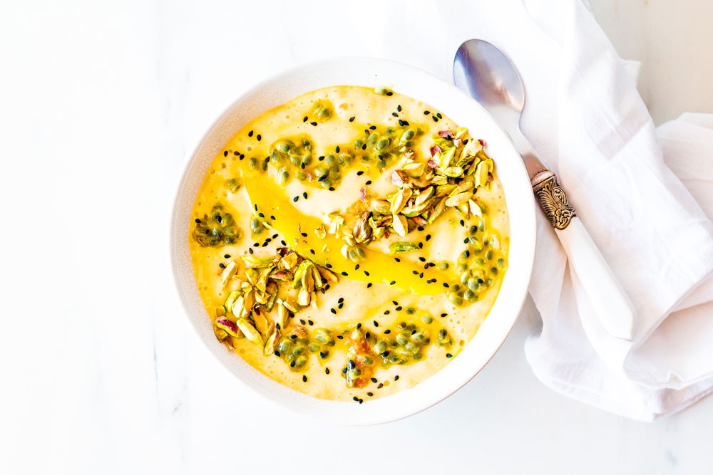 This Mango, Banana & Passion Fruit Smoothie Bowl is a thick blend of frozen and fresh fruit, topped with nuts and seeds that's easy, nutritious, and fun to eat and prepare. https://www.spotebi.com/recipes/mango-banana-passion-fruit-smoothie-bowl/